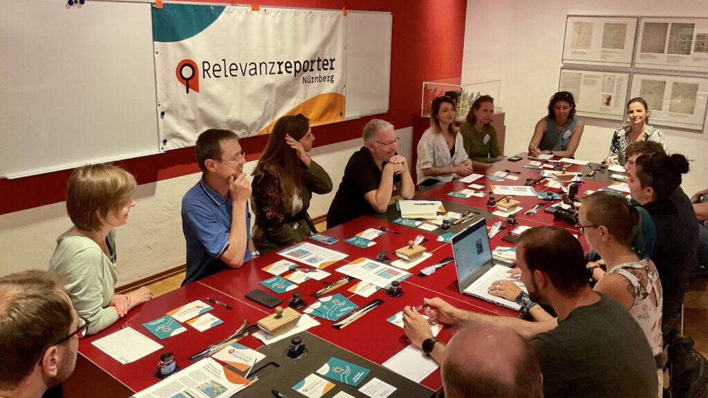 Ein Blick in die offene Redaktionskonferenz der Relevanzreporter: Gäste und Redaktionsmitglieder debattieren über mögliche Themen und wie man diese umsetzen könnte.