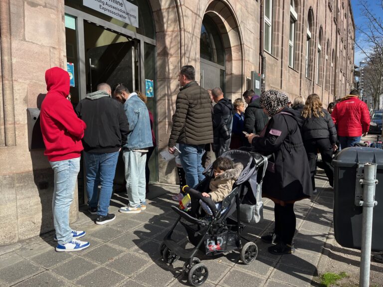 Vor einem alten Gebäude in Nürnberg stehen rund 15 Personen, die offensichtlich auf ihren Einlass warten.